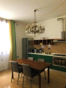 eine Küche mit einem Holztisch und einem Kronleuchter in der Unterkunft Eufemia27 in Verona