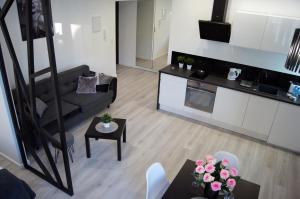 ein Wohnzimmer mit einem Sofa und einem Tisch in der Unterkunft Black & White Apartament in Toruń