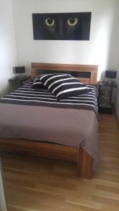 a bed with a black and white pillow with a cat on the wall at Ferienhaus Congolo in Lontzen