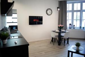 Televízia a/alebo spoločenská miestnosť v ubytovaní Black & White Apartament