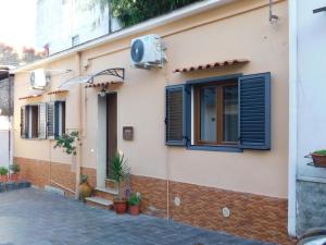 a house with blue shutters and a window at Casa del Principe in Ottaviano