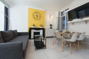 a living room with a couch and a table at L'Olivaroise in Toulon +8 photos