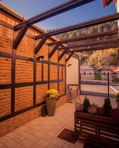 a wooden pergola on a patio with a fence at Villa Boutique ARNICA in Braşov