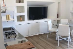 a living room with a tv and a table with chairs at LOFT12 - Luxury Apt. in Santa Maria Capua Vetere