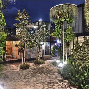 Tanjong Tokong的住宿－Landmark By Katana 4BR Romantic Seaview Homestay Gurney无敌海景四房套房，一座种有树木的庭院和一座夜间建筑