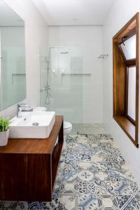a bathroom with a sink and a toilet and a mirror at Casa Villamil Boutique Hotel in Copán Ruinas