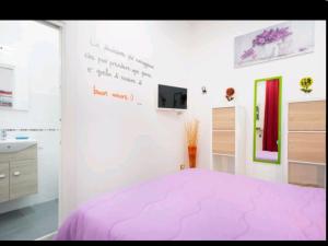 um quarto com uma cama rosa e uma parede branca em Flower Power em Nápoles