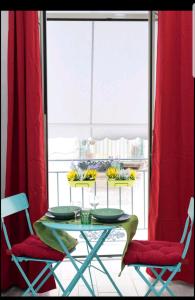 uma mesa com duas cadeiras e uma cortina vermelha em Flower Power em Nápoles