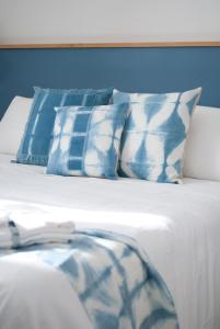 ein Bett mit blauen und weißen Kissen darauf in der Unterkunft L'Alighieri in Monterotondo