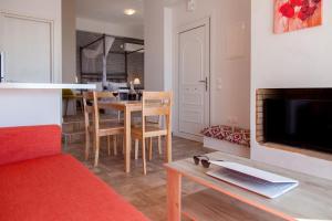 a living room with a table and a tv and a kitchen at Ble on Blue in Athani