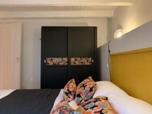 uma pessoa pés em uma cama com um armário preto em Les Apparts de Charly-Le Duplex du Marché em La Rochelle