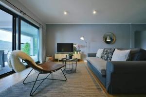 a living room with a couch and a chair and a television at Apartment Vanilla I with beautiful Seaview in Rabac