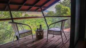 two chairs on a porch with a view of the forest at Jungle Safari Resort & Holiday Villa in Nashik