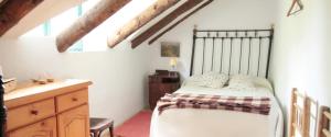 um quarto com uma cama e uma cómoda em madeira em Jardín de Hoz em Hoz de Jaca