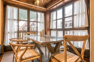 a dining room with a table and chairs and windows at Invernalia by Totiaran in Baqueira-Beret