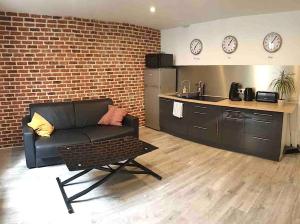 ein Wohnzimmer mit einem Sofa und einer Küche in der Unterkunft Appart' 2 pièces Orléans Centre avec Cuisine in Orléans