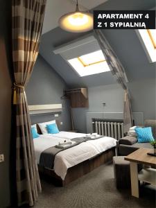 a bedroom with a large bed and a skylight at Kamienica Grand Starówka in Elblag