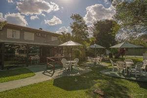 Un patio con sillas, mesas y sombrillas. en SJ Jaguariaíva - San Juan Jaguariaíva, en Jaguariaíva