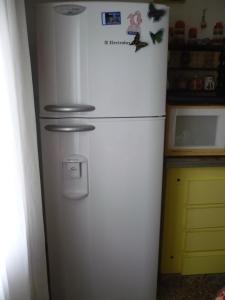 un frigorifero bianco in una cucina con magneti di mar de ajo norte dto. 3 amb frente al mar P.B. a Mar de Ajó