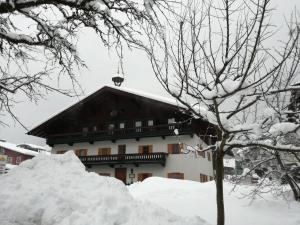 un bâtiment avec une pile de neige devant lui dans l'établissement Karrerhof, à Walchsee