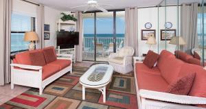uma sala de estar com mobiliário laranja e vista para o oceano em Sunswept 701 Condo em Orange Beach