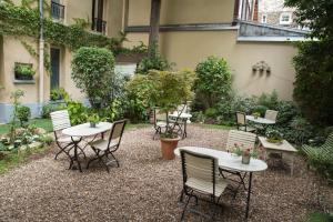 a group of tables and chairs in a courtyard at Hôtel de l'Avre in Paris