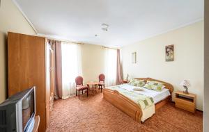 een slaapkamer met een bed en een tv. bij Olimp Soup&Bed in Ivano-Frankovo