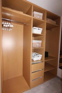 a closet with wooden shelves and baskets at Orly Club Coral Arena Dorada in Puerto del Carmen