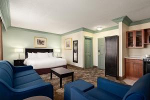 um quarto de hotel com uma cama e cadeiras azuis em Nova Inn Yellowknife em Yellowknife