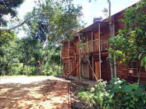 uma cabana de madeira com um alpendre e um deque em Jungle cottage em Sreemangal