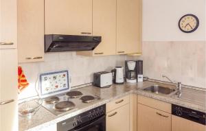 cocina con fogones, fregadero y reloj en 1 Bedroom Amazing Apartment In Mellenthin, en Mellenthin