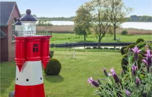 a red and white lighthouse sitting in a yard at Gorgeous Apartment In Mellenthin in Mellenthin