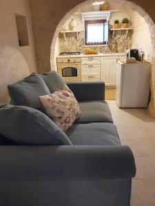 a living room with a blue couch in a kitchen at I Trulli di Nonna Maria in Alberobello