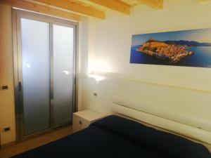 pokój z łóżkiem i obrazem na ścianie w obiekcie Relax house w Cefalù