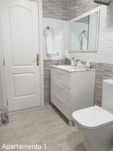 Baño blanco con aseo y lavamanos en Apartamento Kings Vegueta en Las Palmas de Gran Canaria