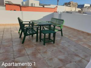 dos sillas verdes y una mesa en el techo en Apartamento Kings Vegueta en Las Palmas de Gran Canaria