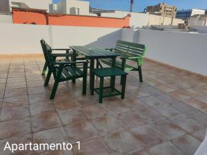 ラスパルマス・デ・グランカナリアにあるApartamento Kings Veguetaの緑の椅子2脚と屋根の上のテーブル