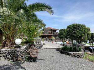 伊科德德洛斯維諾斯的住宿－CASA RURAL LA PERLA NEGRA，棕榈树和长椅的度假村和大楼