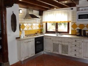 une cuisine avec des armoires blanches, un évier et une fenêtre dans l'établissement CASA RURAL LA PERLA NEGRA, à Icod de los Vinos