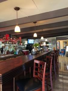 un bar con barra de madera y sillas en Tio Pepe’s Guest House, en Aibonito