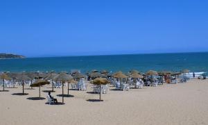 a group of umbrellas and chairs on a beach at Appartement à La Marsa in Tunis