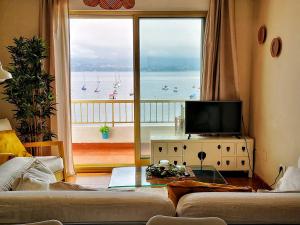 a living room with a large window with a view of the ocean at Apartamento Rías Baixas - 1a Línea Playa Raxó in Raxo