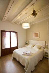 a bedroom with a large white bed and a window at Casa Rural Villazón II - A 16 km de Pamplona in Obanos