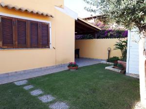 a backyard of a house with a green lawn at Alice's House - Monolocale in Pula