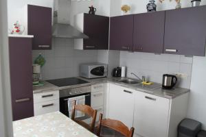 a kitchen with white cabinets and a table and a microwave at Casa Maria in Saint-Vith