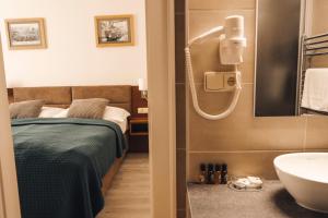 een badkamer met een bed en een wastafel bij U Medvidku-Brewery Hotel in Praag