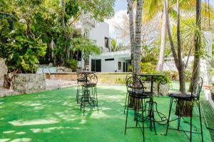 a group of chairs and tables on a lawn at Private Villa 10 Rooms, Private Pool, Walk to Beach in Playa del Carmen