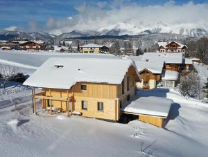 罗尔穆斯Bergchalet Raffalt的一座覆盖着雪的木屋,后面是群山