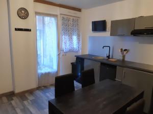 a kitchen with a counter and a table and a window at Repaire des Corsaires Normands in Le Tréport