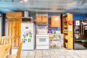 a kitchen with white appliances and wooden cabinets at Getaway Bar on Easy Street in Rockaway Beach +14 photos